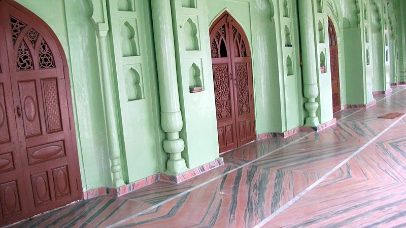 Red timber doors along the green wall