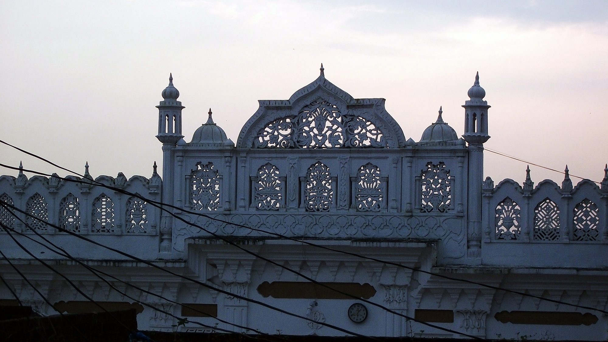 The carved parapet of the mosque at sunset